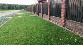 Загородный дом с ограждением из металлоштакетника